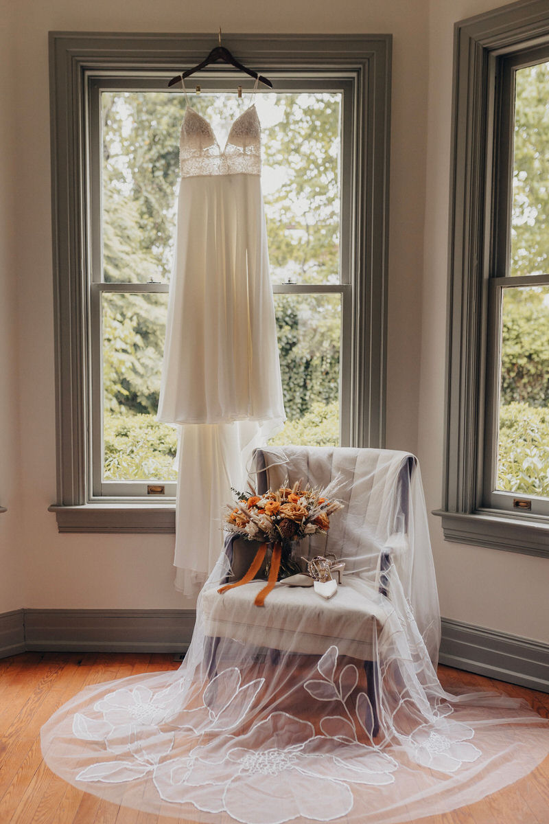 wedding dress hanging in a windowsill 