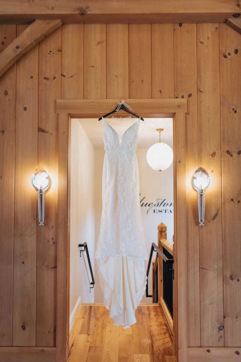 wedding dress hanging in a wooden dorway