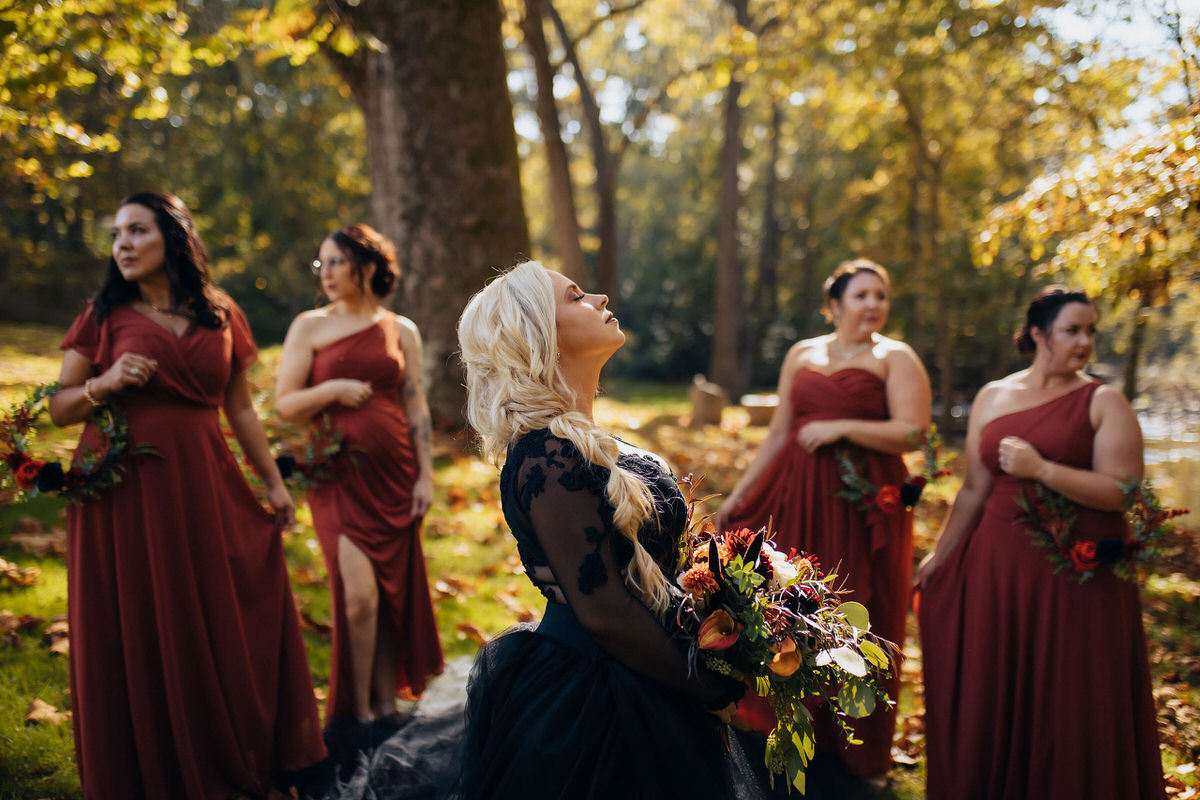 bride and wedding party standing in a wooded area