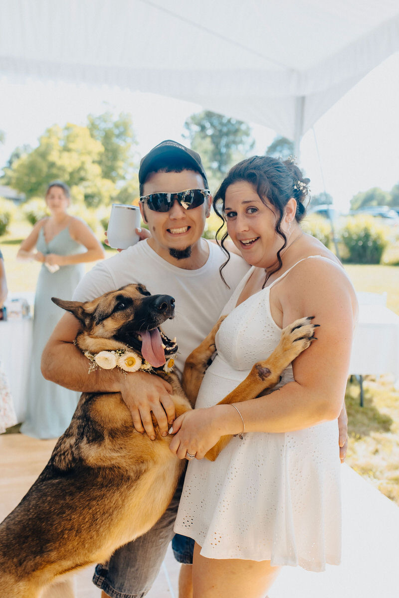 married couple smiling and dancing with a german shepherd