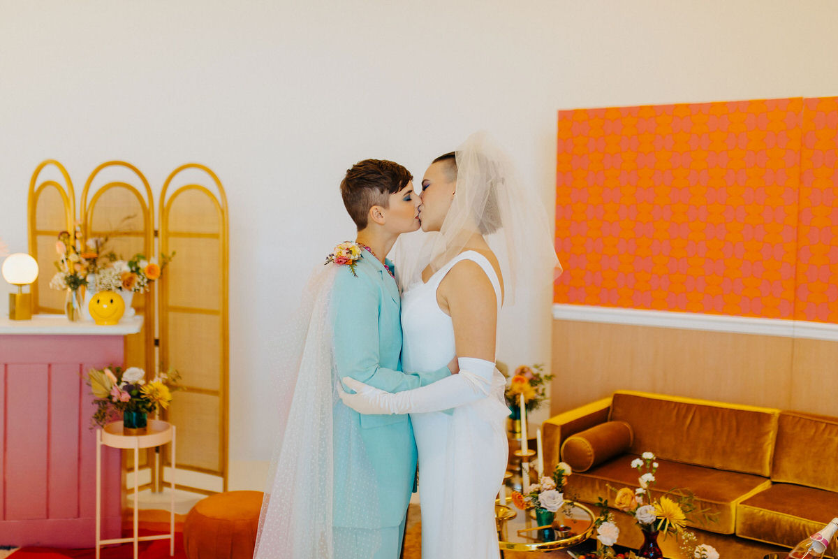 couple in bright colored clothes kissing