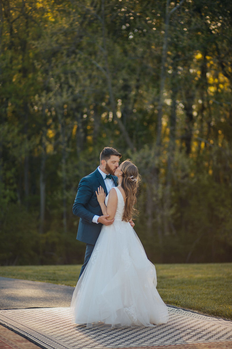 couple kissing on an outdoor wedding reception dance floor