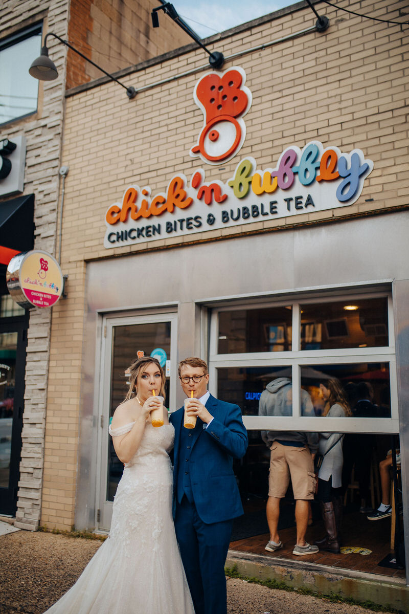 couple drinking bubble tea in their wedding outfits