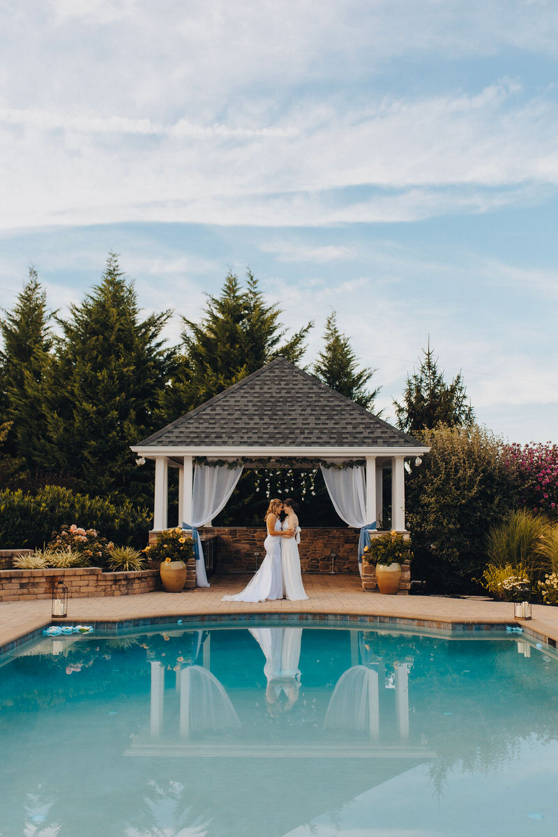 couple standing forehead to forehead at the end of a pool