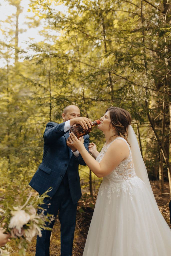 wedding couple drinking a bottle of alcohol together