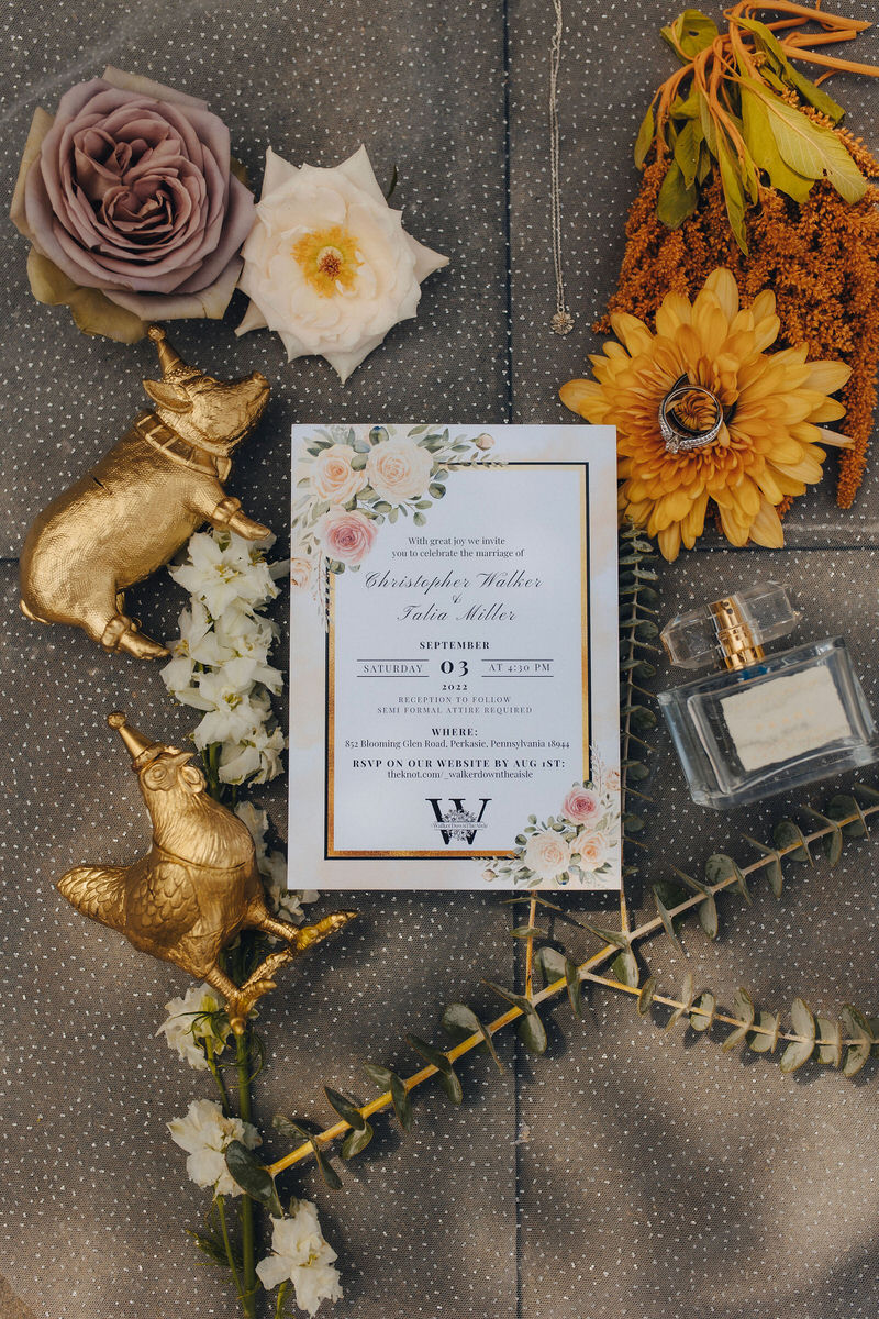 jewelry, wedding invitation, and perfume laid next to each other