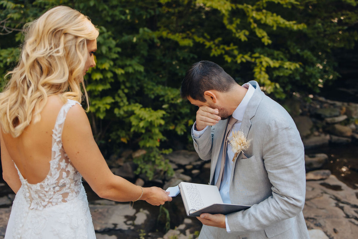 wedding couple holding a notebook and crying