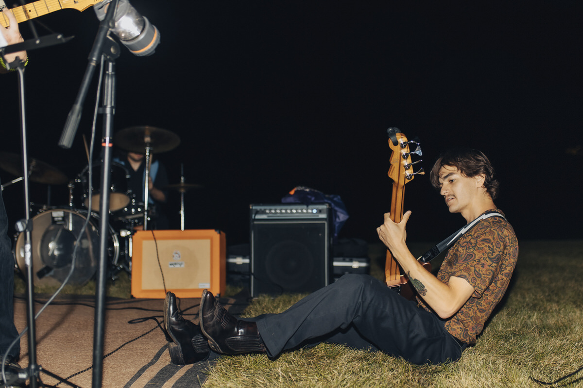 person sitting on the ground playing a bass