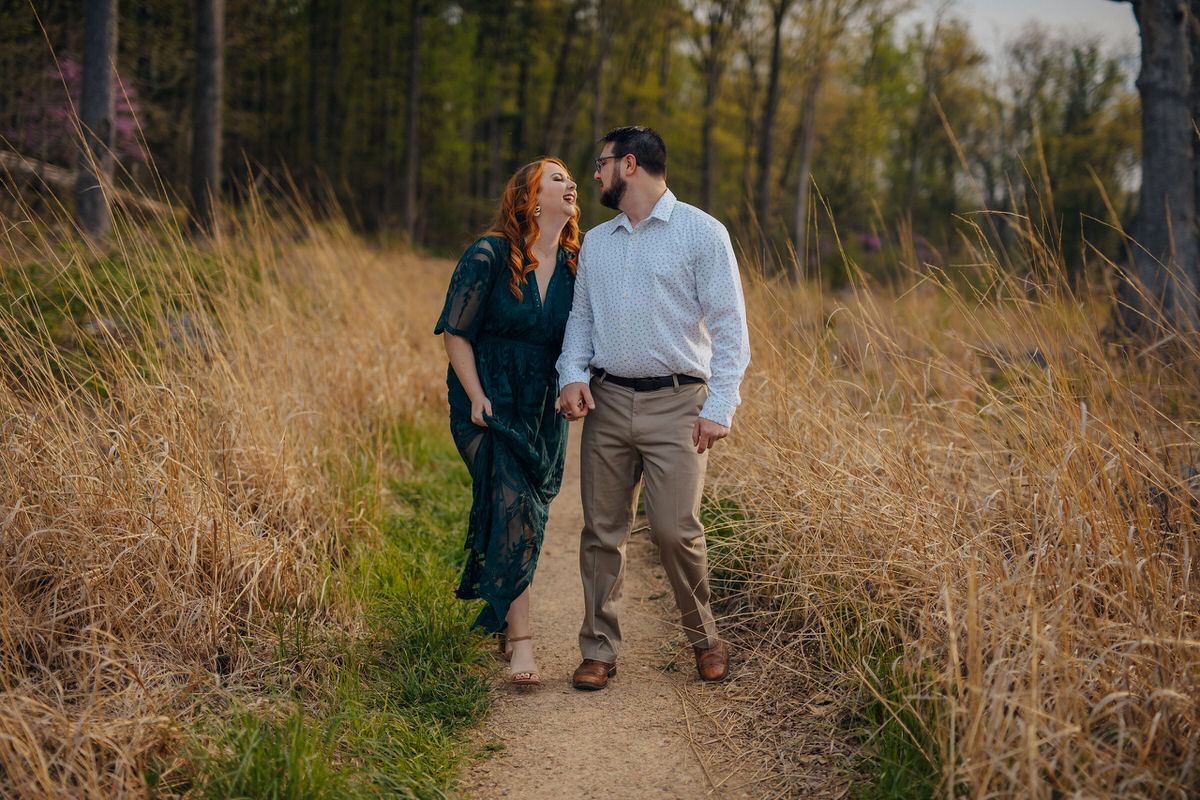 couple holding hands on a walking path 