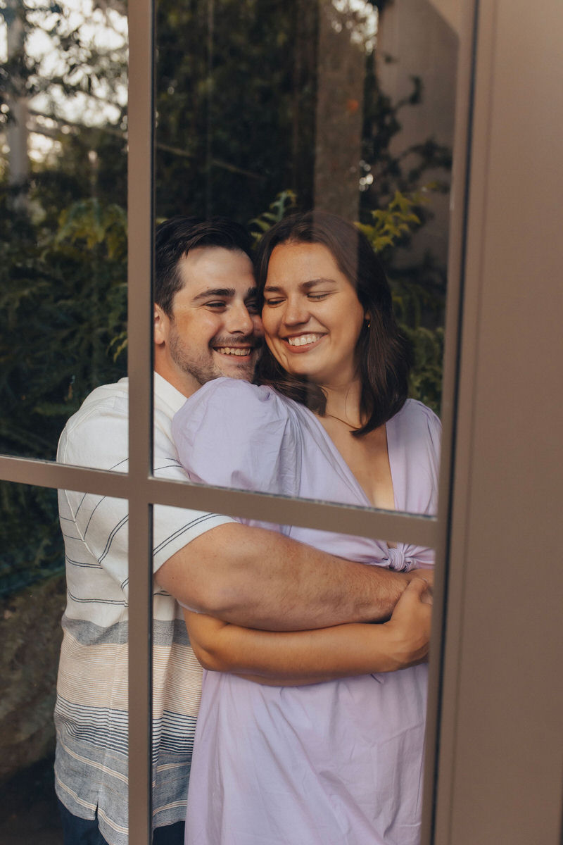 couple hugging and looking through a window