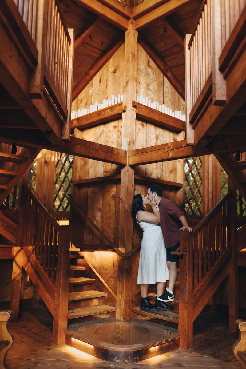 couple kissing on a wooden staircase 