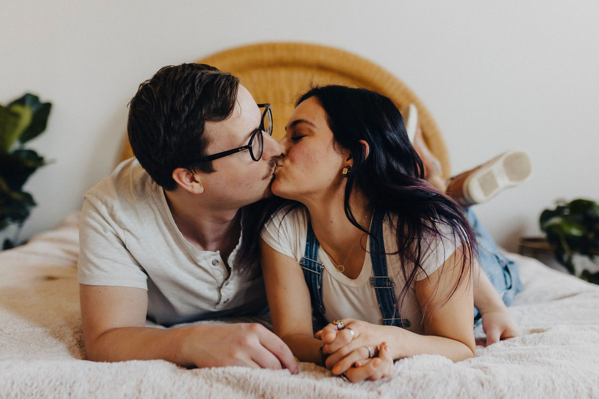 couple kissing on a bed 