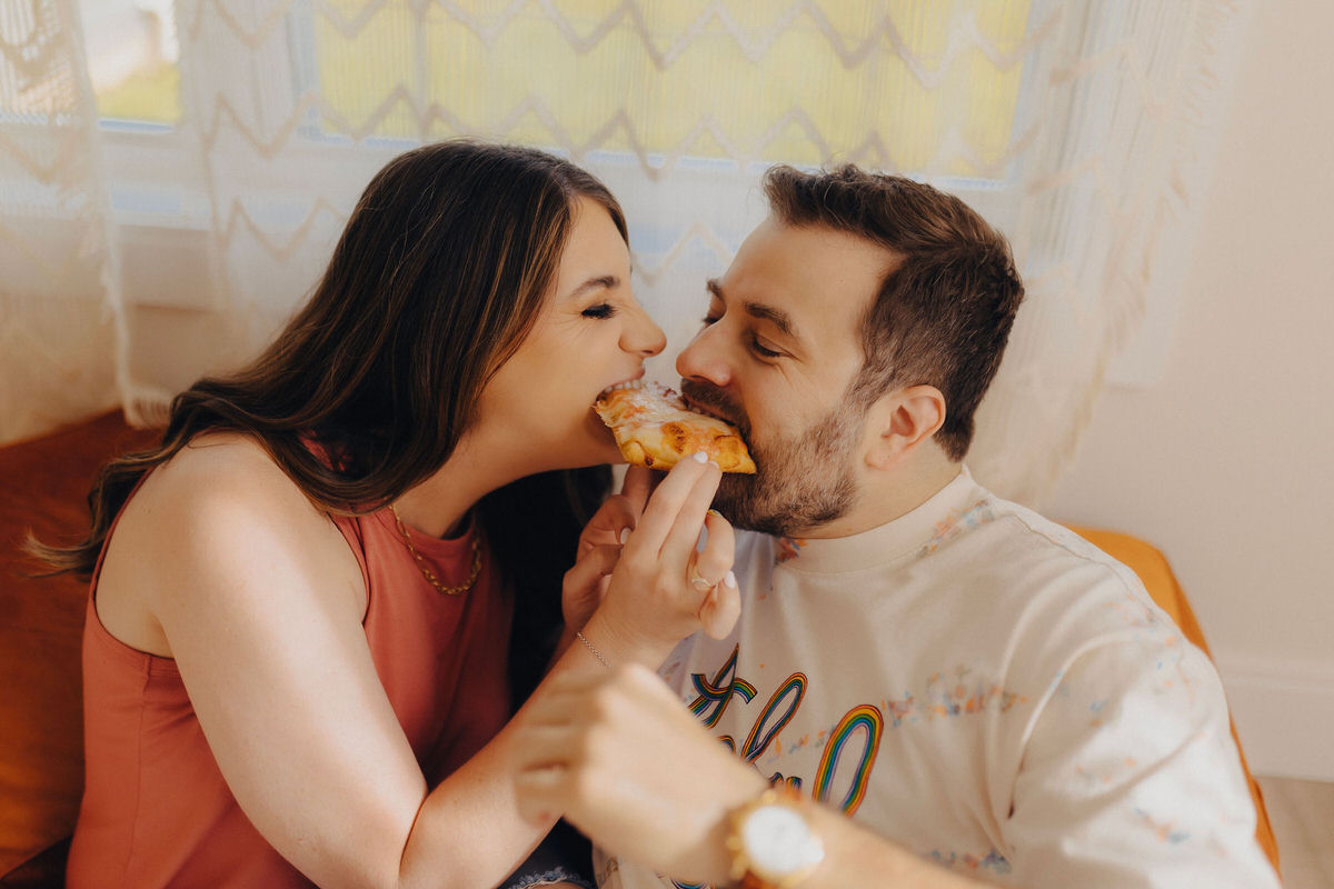 couple eating a piece of pizza together
