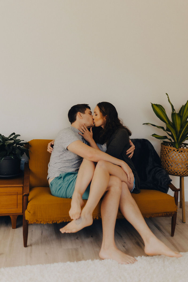 couple kissing on a couch 