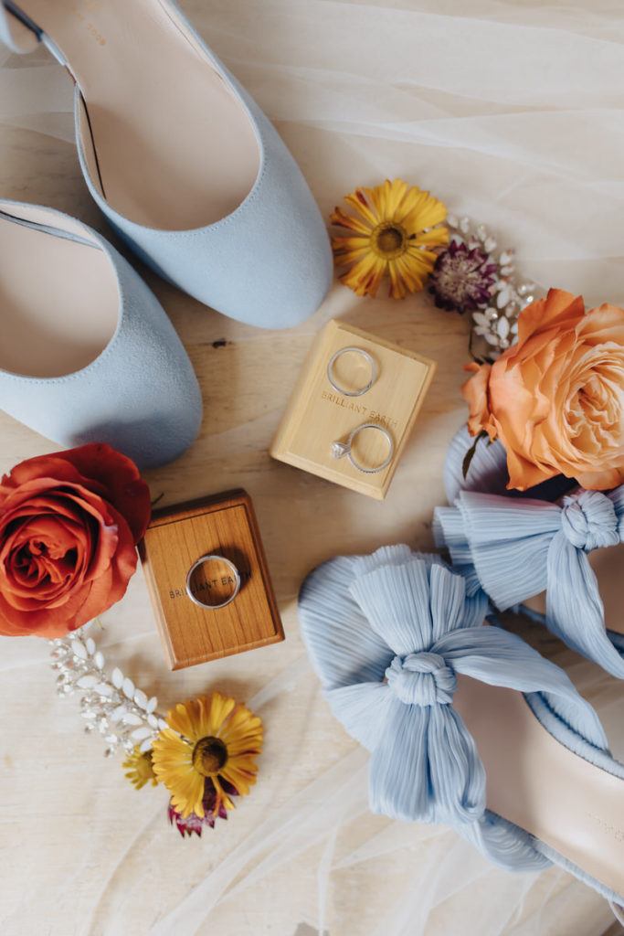 flowers, shoes, and rings laid out on top of a vail 