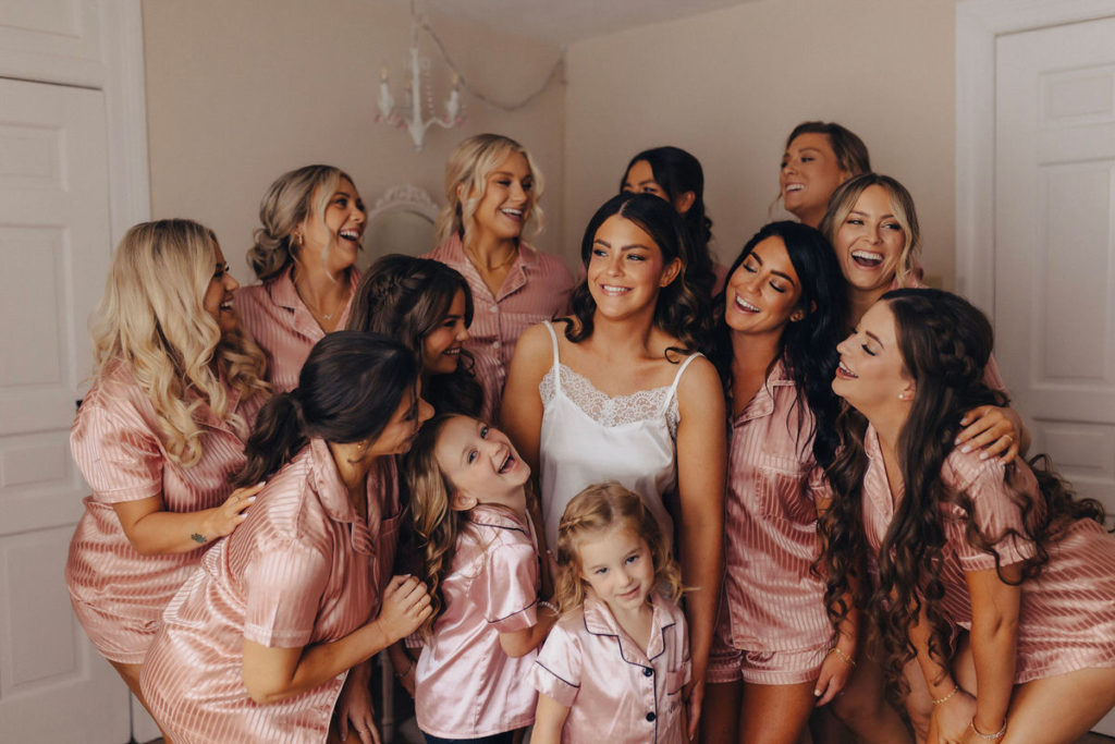 wedding party in matching outfits standing in a group and laughing