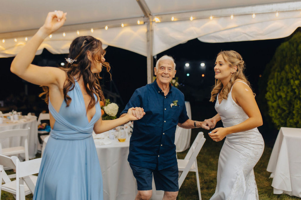 three people dancing together in a tent at a wedding reception 
