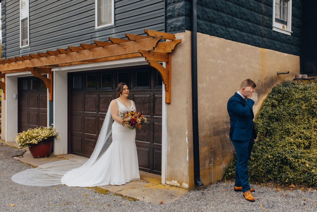 wedding couple standing around the corner from each other about to do a first look while one of them is crying 

