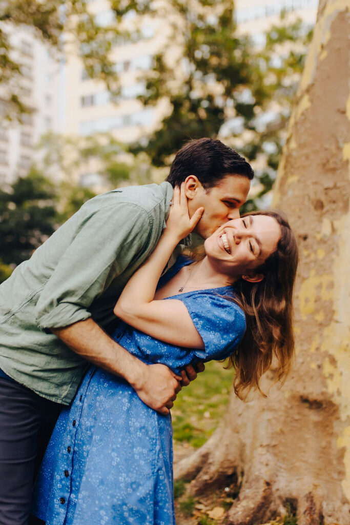 A person kissing their partner on the cheek as they smile. 