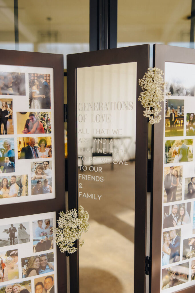 A decorative photo board at a wedding displaying images of various generations with the text 'Generations of Love: All that we are and all that we hope to be we owe to our friends & family'.