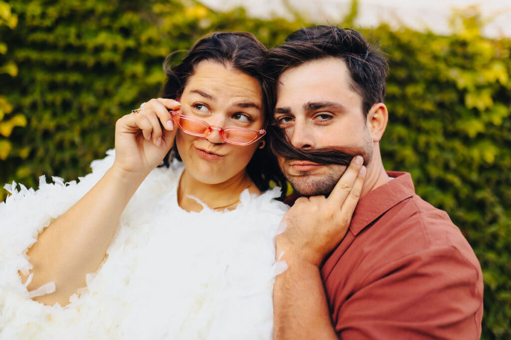 A person using their partner's hair as a mustache
