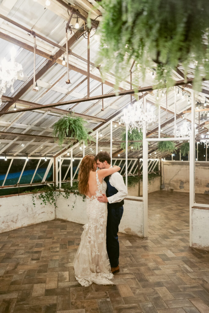 A newly-wed couple holding each other as they dance privately at the end of their wedding night
