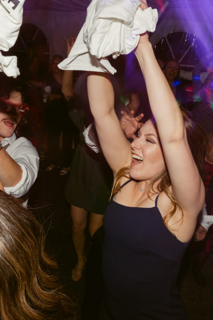 A wedding guest catching a customized t-shirt during a wedding t-shirt toss