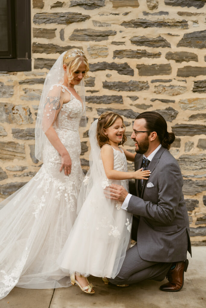 Bride's daughter hugs a guest as she does a first look with her friends and family